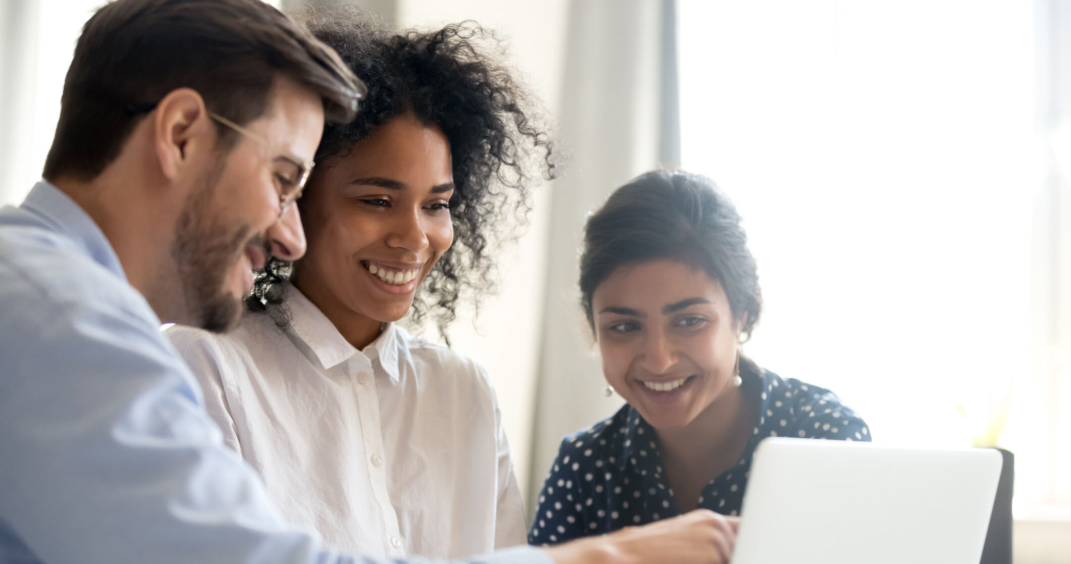Diverse happy interns learning new computer software listening to mentor teacher coach teaching explaining online project application on laptop, smiling multi-ethnic coworkers work together in office